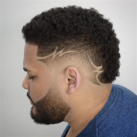 The low taper fade on the sides and back creates a neat and clean look, while the design adds a unique and artistic touch. . Low fade with design